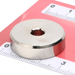 Magneetti kotelossa, halkaisija 25 mm, jossa on poraus litteäpäistä ruuvia varten, neodyymi magneetti