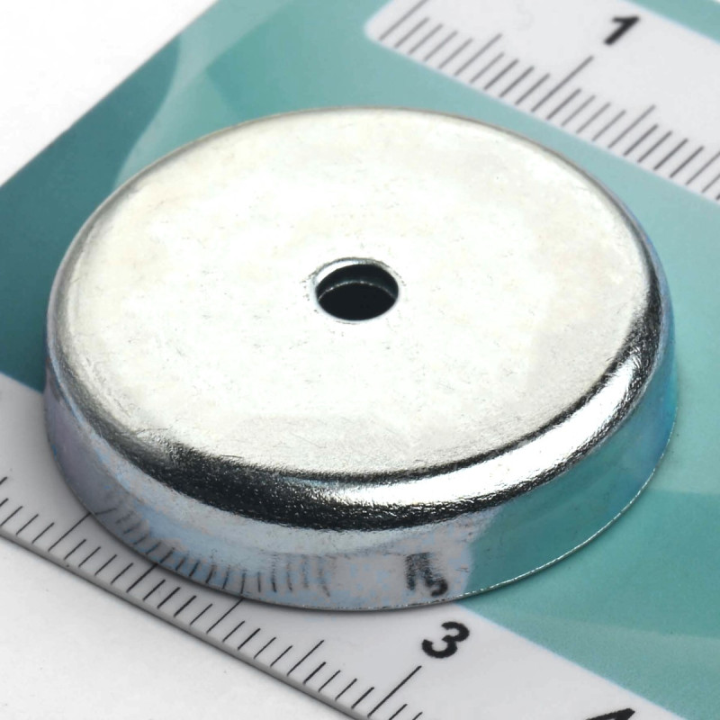 Magneetti kotelossa, halkaisija 32 mm, jossa on reikä litteäpäistä ruuvia varten, ferriittiä.